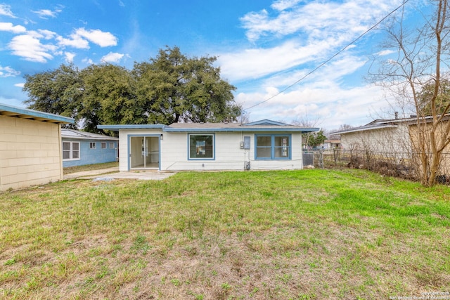 rear view of house with a patio and a lawn