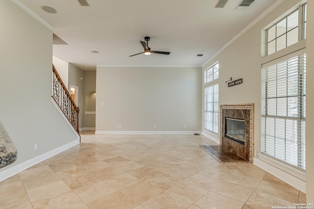 unfurnished living room with ornamental molding, light tile patterned floors, ceiling fan, and a premium fireplace