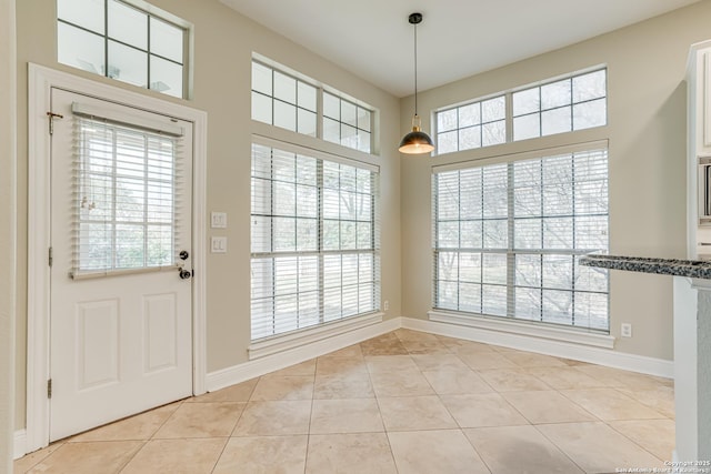 unfurnished dining area with light tile patterned flooring and a wealth of natural light