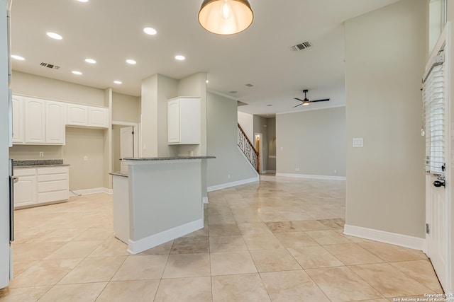 kitchen featuring white cabinetry, dark stone countertops, ceiling fan, and light tile patterned floors