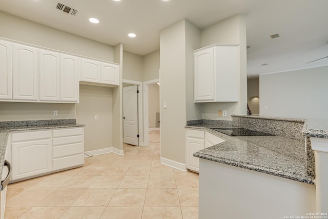 kitchen with light tile patterned floors, white cabinetry, black electric stovetop, and dark stone countertops