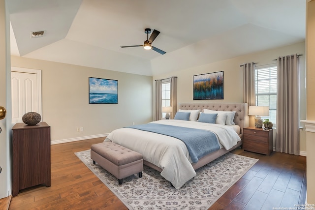 bedroom with a tray ceiling, dark hardwood / wood-style floors, and ceiling fan