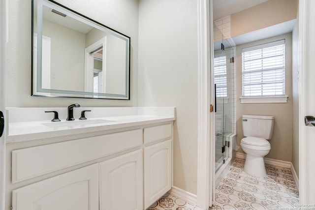 bathroom with toilet, vanity, tile patterned flooring, and a shower with shower door