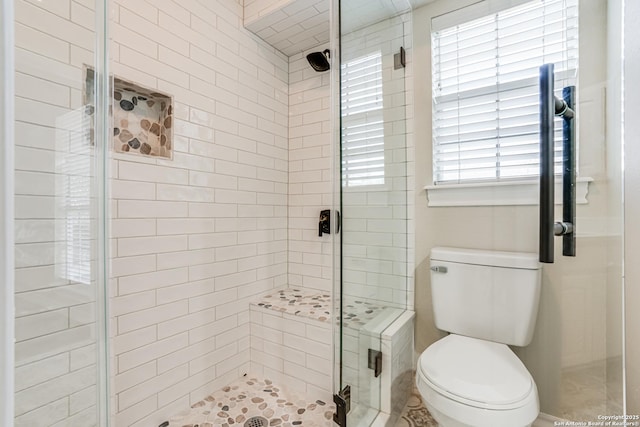 bathroom featuring an enclosed shower and toilet