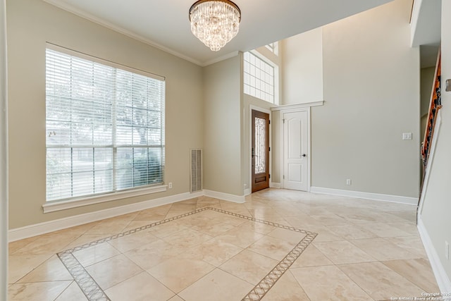 tiled empty room featuring a chandelier and ornamental molding