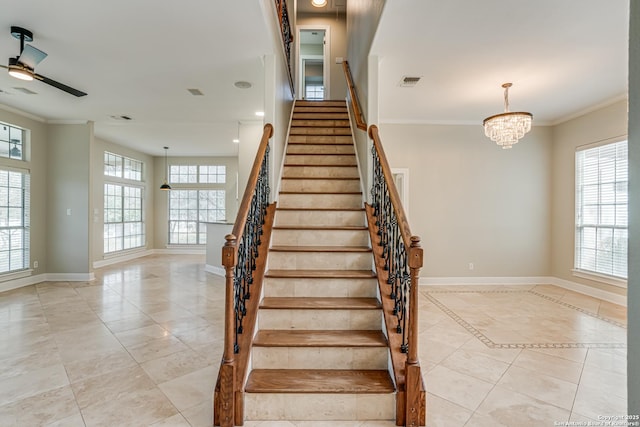 staircase featuring tile patterned flooring, crown molding, and ceiling fan with notable chandelier