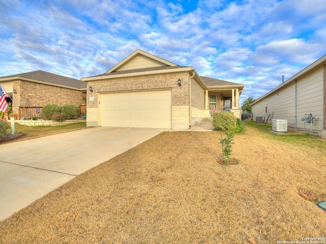 single story home with brick siding, central air condition unit, concrete driveway, a garage, and a front lawn