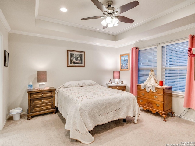 bedroom featuring baseboards, a raised ceiling, light colored carpet, ceiling fan, and ornamental molding