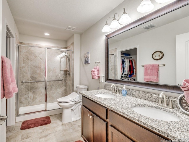 full bathroom with visible vents, a sink, a spacious closet, and a shower stall