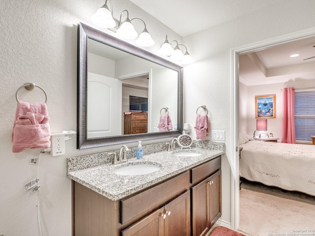 bathroom with double vanity, a sink, and connected bathroom