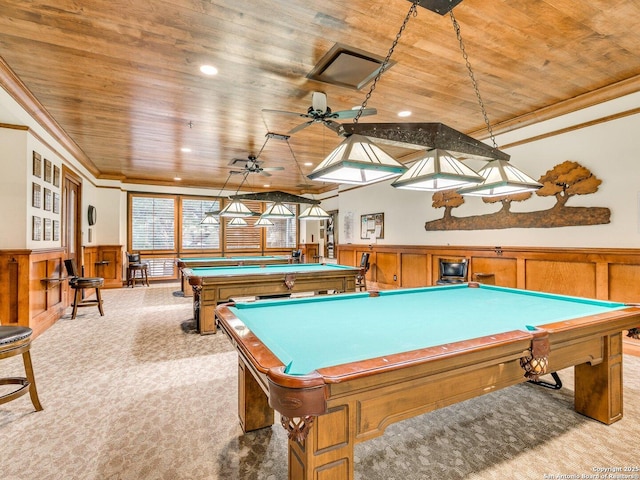 game room featuring light carpet, wooden ceiling, ornamental molding, and wainscoting