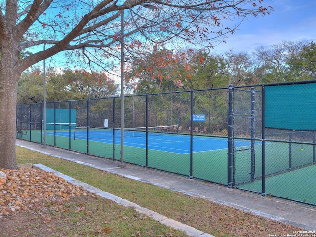 view of tennis court featuring fence