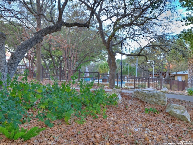 view of yard featuring fence and a pool