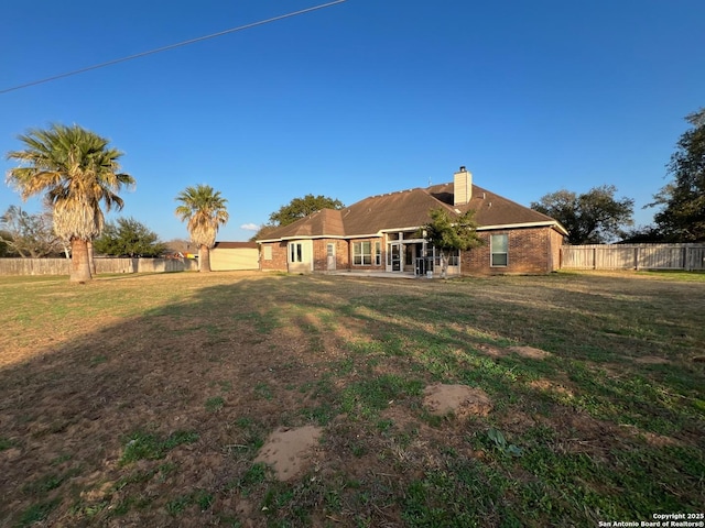 back of property with a lawn and a patio