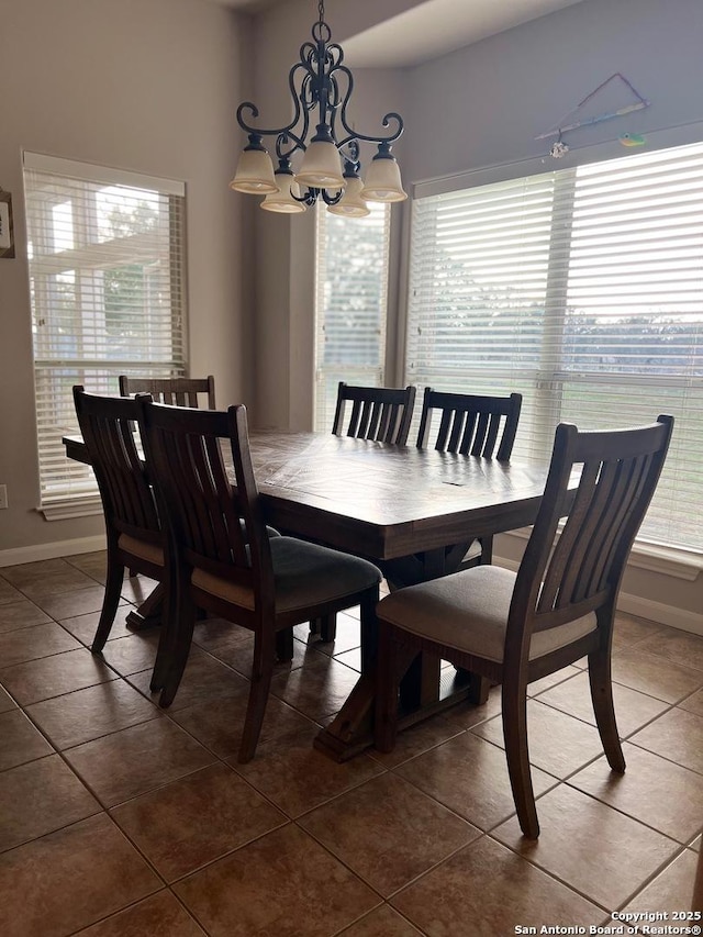 tiled dining room featuring a notable chandelier