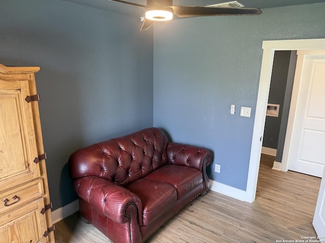 living area with ceiling fan and wood-type flooring