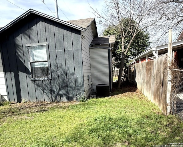 view of side of property with a yard and cooling unit