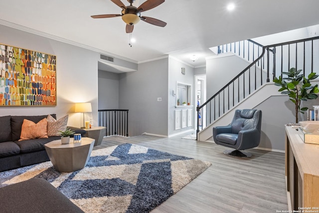 living room featuring ceiling fan, light hardwood / wood-style flooring, and crown molding