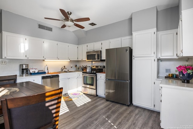 kitchen featuring white cabinets, stainless steel appliances, dark hardwood / wood-style flooring, and backsplash