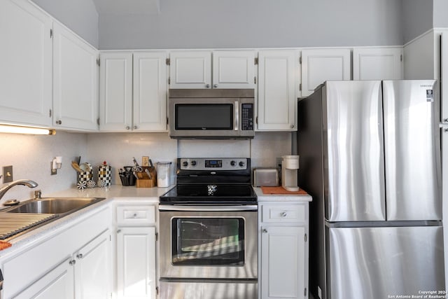 kitchen featuring white cabinetry, stainless steel appliances, and tasteful backsplash