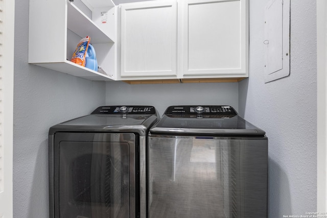 laundry area with separate washer and dryer and cabinets