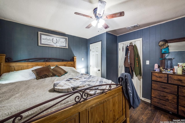 bedroom with dark wood-type flooring, ceiling fan, and a closet