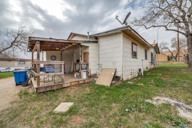 rear view of property featuring a yard and a deck