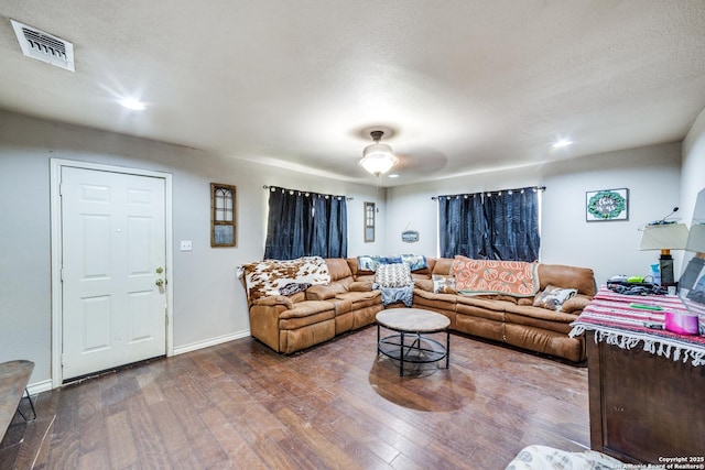 living room with a textured ceiling, hardwood / wood-style flooring, and ceiling fan