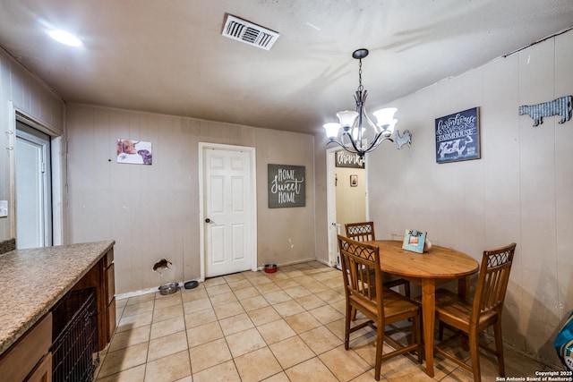 tiled dining room with a chandelier