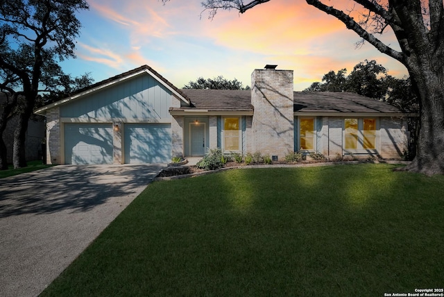 mid-century modern home with an attached garage, brick siding, concrete driveway, a lawn, and a chimney