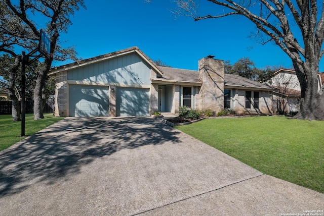 mid-century home featuring an attached garage, brick siding, a chimney, and a front yard