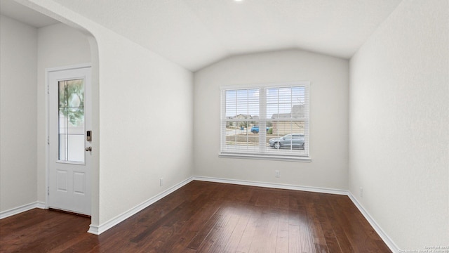 entrance foyer featuring vaulted ceiling and dark hardwood / wood-style floors