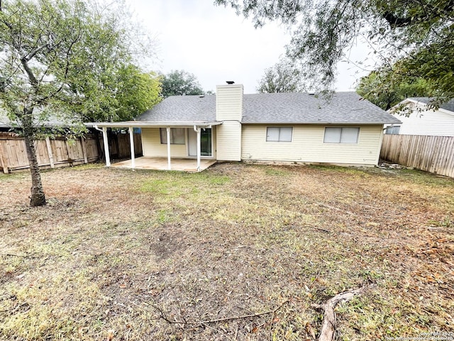 rear view of house featuring a yard and a patio area