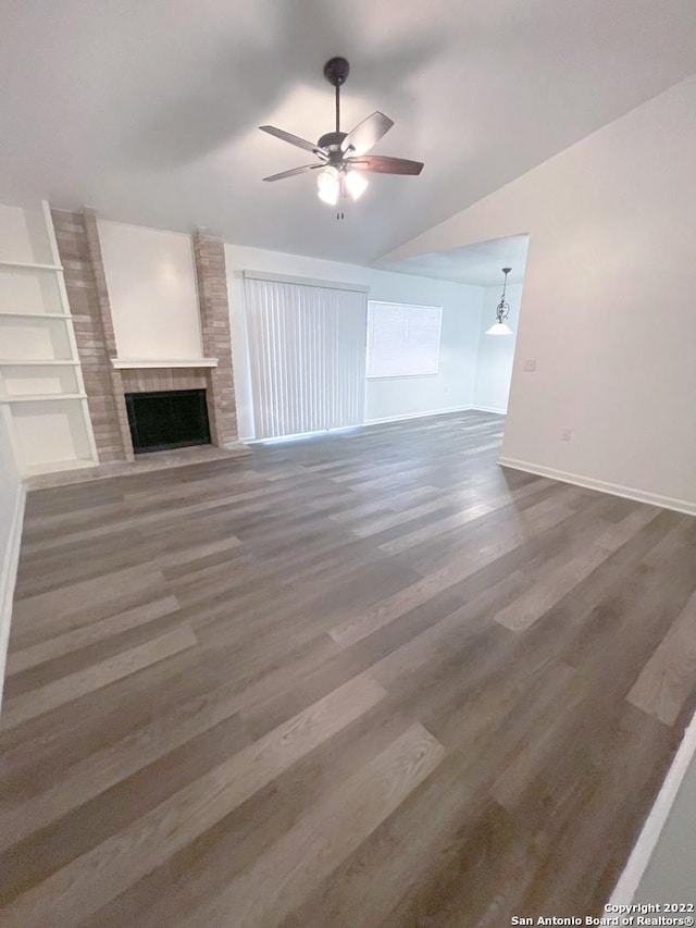 unfurnished living room featuring hardwood / wood-style floors, vaulted ceiling, ceiling fan, and a fireplace