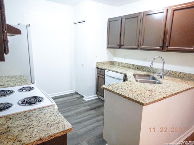 kitchen featuring white appliances, light stone counters, dark hardwood / wood-style flooring, sink, and kitchen peninsula