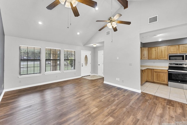 unfurnished living room with high vaulted ceiling, light hardwood / wood-style flooring, ceiling fan, and beam ceiling