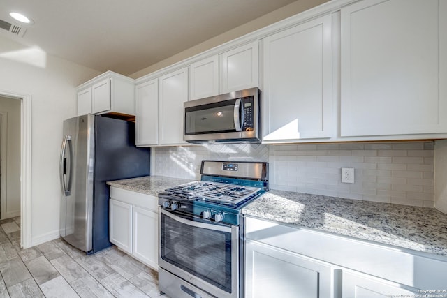 5023 Stockman Dr, San Antonio, TX 78247 - kitchen featuring visible vents, white cabinetry, decorative backsplash, and appliances with stainless steel finishes