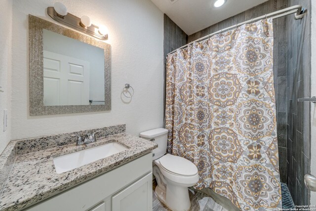 5023 Stockman Dr, San Antonio, TX 78247 - bathroom with a textured wall, vanity, a shower with curtain, and toilet