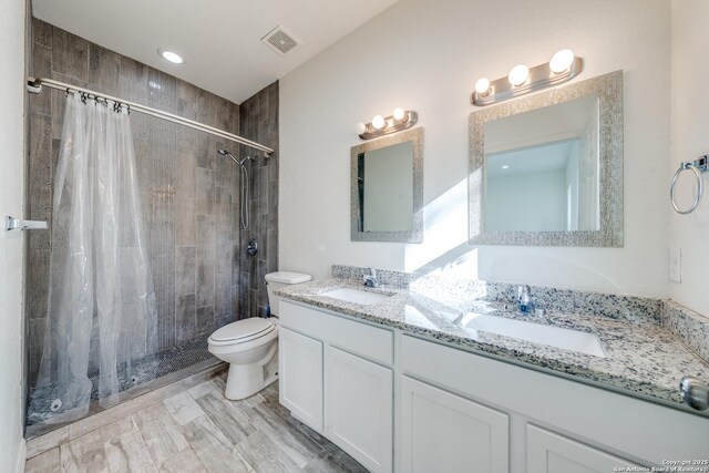 5023 Stockman Dr, San Antonio, TX 78247 - bathroom with a sink, visible vents, toilet, and tiled shower