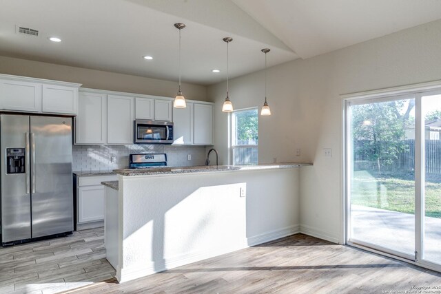 5023 Stockman Dr, San Antonio, TX 78247 - kitchen featuring light wood finished floors, backsplash, white cabinets, and stainless steel appliances