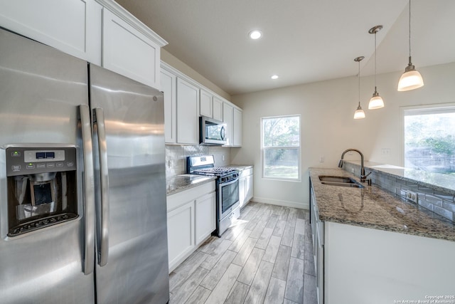 5023 Stockman Dr, San Antonio, TX 78247 - kitchen featuring a sink, appliances with stainless steel finishes, dark stone countertops, and a healthy amount of sunlight