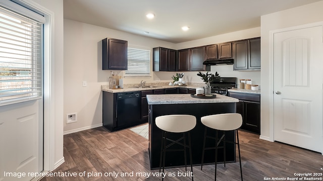 kitchen with sink, a center island, a kitchen breakfast bar, black appliances, and dark brown cabinetry