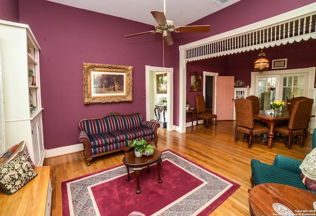 living room featuring lofted ceiling, ceiling fan, and wood-type flooring