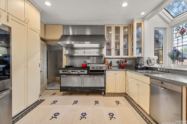 kitchen featuring a sink, appliances with stainless steel finishes, wall chimney range hood, and recessed lighting