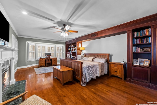 bedroom featuring a high end fireplace, visible vents, baseboards, ornamental molding, and dark wood-style floors