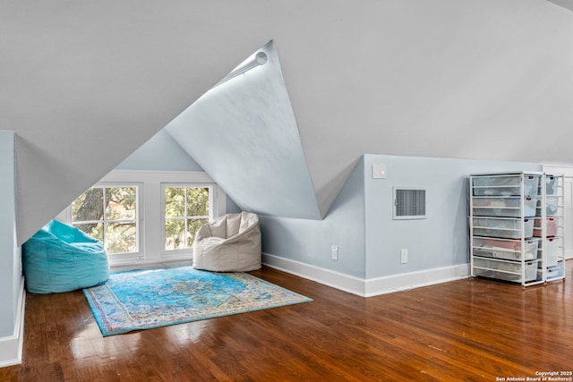 sitting room with vaulted ceiling, wood finished floors, visible vents, and baseboards