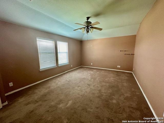 carpeted spare room with ceiling fan