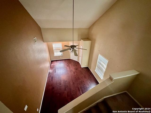 interior space featuring ceiling fan, lofted ceiling, and dark hardwood / wood-style flooring