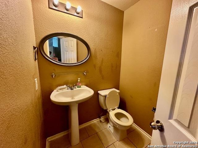 bathroom with toilet and tile patterned floors