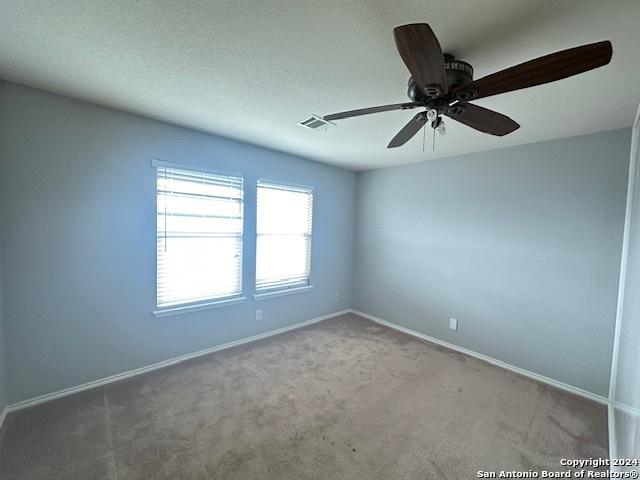 carpeted empty room featuring ceiling fan